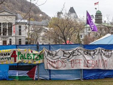 Temporary fencing with banners reading 'Concordia 4 Palestine' and "All eyes on Rafah / Hands off Lebanon' with the McGill campus in the background