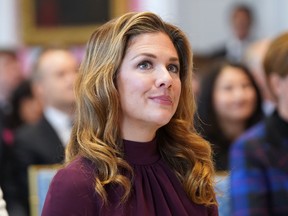 A woman seated with others looks toward a speaker off-camera