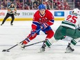 Canadiens' Brendan Gallagher, wearing the team's red jersey, has the puck on his stick as he is pressured by the Wild's Jonas Brodin during game at the Bell Centre this season.