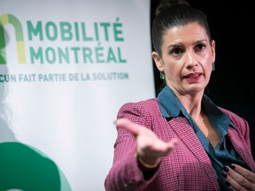 Quebec Transport Minister Geneviève Guilbault gestures with her right hand as she stands in front of a sign reading Mobilité Montréal.