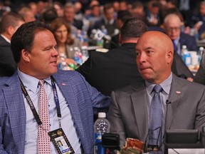 Jeff Gorton, left, and Kent Hughes sit at a table in a large room with banquet seating