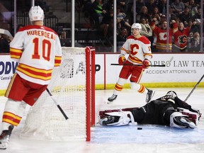 Flames' Jonathan Huberdeau and Yegor Sharangovich skate past as Coyotes goalie Connor Ingram lays sprawled on the ice with the puck behind him at 4,600-seat Mullett Arena in Tempe, Ariz.
