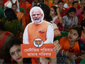 A Bhartiya Janata Party (BJP) supporter holds a cutout picture of India's Prime Minister Narendra Modi during a public meeting addressed by Modi in Barasat on the outskirts of of Kolkata on March 6, 2024.