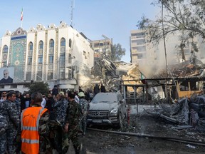 Emergency and security personnel inspect the site of strikes that hit a building annexed to the Iranian embassy in Syria's capital Damascus, on April 1, 2024.