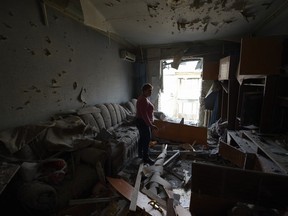 A woman stands among the rubble in her damaged apartment hit by recent shelling, what local officials called a Ukrainian military strike, in Donetsk, Russian-controlled Ukraine, on April 2, 2024, amid ongoing Russian-Ukrainian conflict.
