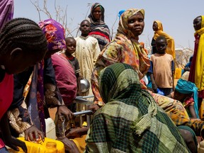 Sudanese refugees gather to fill cans with water from a water point in the Farchana refugee camp, on April 8, 2024.