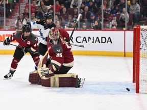 Montreal goalie Ann-Renée Desbiens, wearing her team's burgundy jersey and in the butterfly position, looks behind her as the puck trickles towards her net during PWHL game against Toronto at the Bell Centre on April 20, 2024.