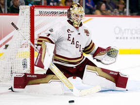 Canadiens prospect Jacob Fowler is seen wearing his teams' white jersey with red, gold and white pads in the butterfly position making a save for the Boston College Eagles.
