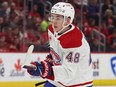 A close-up of Lane Hutson, wearing the Canadiens' road white jersey and holding his stick in both hands during game in Detroit Monday night.