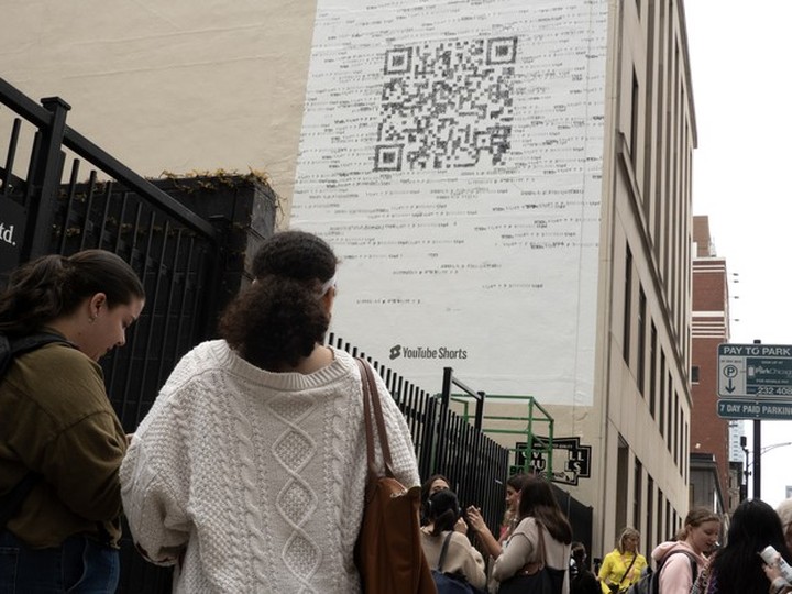  Taylor Swift fans gather outside a building where a mural featuring a large QR code was being painted to promote Swift’s latest album, “The Tortured Poets Department,” on April 17, 2024 in Chicago.