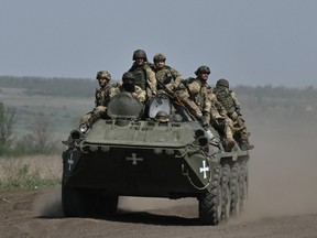 Ukrainian servicemen ride an armored personnel carrier (APC) in a field near Chasiv Yar, Donetsk region, April 27, 2024, amid the Russian invasion of Ukraine.