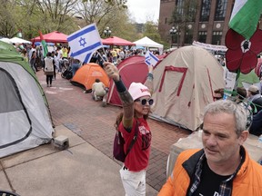 Pro-Israel protesters walk through an encampment created by pro-Palestinian students on the campus of the University of Michigan in Ann Arbor, Michigan on April 28, 2024.