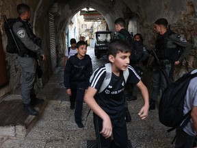 Children walk past Israeli security forces deployed at one of the entrances of Jerusalem's Old City following a reported stabbing attack on April 30, 2024. Several deadly knife attacks have taken place across Israel and the occupied West Bank since the war in Gaza broke out following Hamas's Oct. 7 attack in southern Israel.