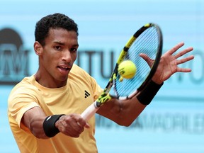 Félix Auger-Aliassime hits a backhand with his tennis racket