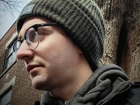 A profile of a man from the neck up. He is wearing a toque.
