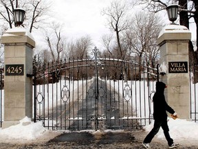 The entrance gates of Villa-Maria College seen in winter, with a person dressed in black walking by.