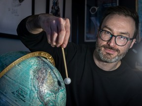 Astronomy fan Trevor Kjorlien illustrates the effect of a solar eclipse on his world globe