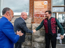 Two men shake hands in front of a sign that says native montreal family clinic.