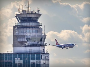 A plane crosses the path of a control tower.