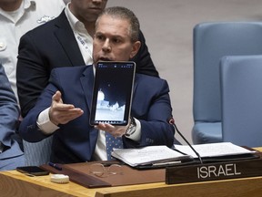 Israeli UN Ambassador Gilad Erdan shows a video of Iranian missiles flying over Al-Aqsa Mosque as he addresses the United Nations Security Council during an emergency meeting at UN headquarters, Sunday, April 14, 2024.