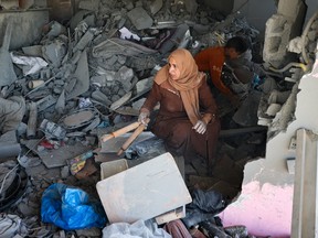 A Palestinian woman salvages belongings from the rubble of a house hit by overnight Israeli bombing in Rafah in the southern Gaza Strip on April 20, 2024, amid the ongoing conflict between Israel and the Hamas movement.
