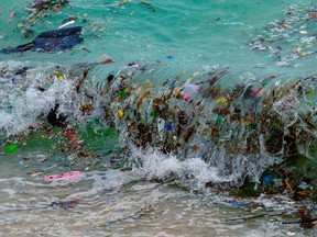 A wave carrying plastic waste and other rubbish washes up on a beach in Koh Samui in the Gulf of Thailand on Jan. 19, 2021.