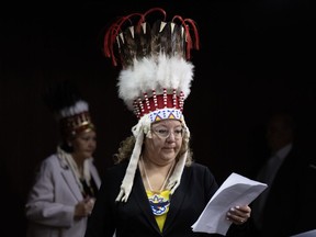 National Chief of the Assembly of First Nations Cindy Woodhouse Nepinak places her papers on the podium at the start of a news conference on Parliament Hill, Wednesday, April 17, 2024 in Ottawa. The minister of Crown-Indigenous relations is calling on Air Canada to "make things right" with the national chief of the Assembly of First Nations whose headdress was removed from a flight's cabin.