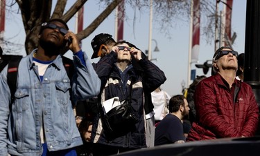 People in Montreal's Old Port view the solar eclipse on Monday, April 8, 2024.