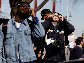 View shows people wearing special glasses to watch the eclipse