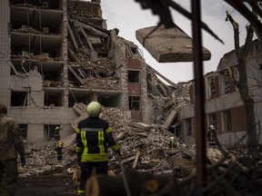 Firefighters work on a building that was partially destroyed after a Russian bombardment in Chernihiv, Ukraine, Wednesday, April 17, 2024.