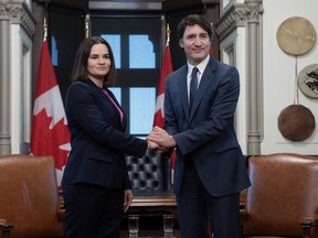 Prime Minister Justin Trudeau and Belarus opposition leader Sviatlana Tsikhanouskaya pose for cameras as they shake hands before a meeting, Monday, April 15, 2024 in Ottawa.