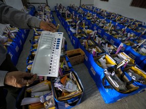 An official holds a mock ballot paper as he prepares bags of election material to be distributed along with the Electronic Voting Machines (EVMs) ahead of the national parliamentary elections in Jorhat, India, Wednesday, April 17, 2024.