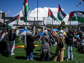 People wave flags during a student encampment for Palestine at the University of British Columbia campus in Vancouver, Monday, April. 29, 2024.