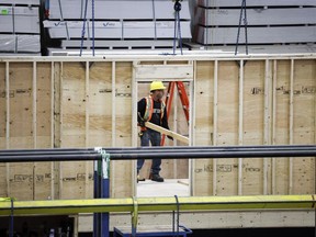 An employee works on a modular home component in Calgary, Friday, April 5, 2024.
