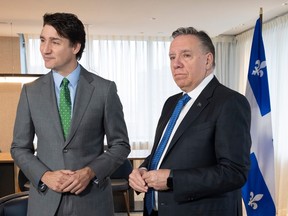 Justin Trudeau and François Legault stand together near a Quebec flag
