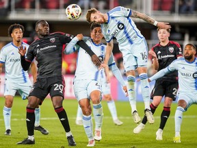 D.C. United and CF Montréal players leap for the ball in a MLS soccer game