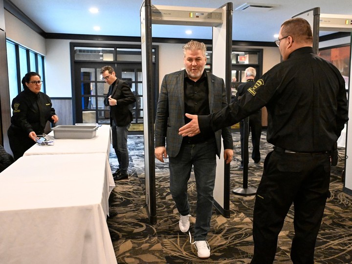 Parti Québécois MNA Pascal Bérubé walks under a metal detector as security is present at a party national council meeting on Saturday, April 13, 2024, in Drummondville. PQ MNA Pascal Paradis, left, empties his pockets before going through.