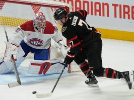 Hockey player bears down to shoot on goaltender