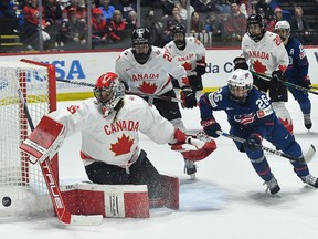 Canada goalie Ann-Renée Desbiens, left, pushes the puck wide of the goal