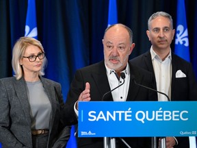 Christian Dubé gestures at a podium standing between Geneviève Biron and Frédéric Abergel