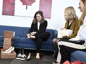 Deputy Prime Minister and Minister of Finance Chrystia Freeland tries on a pair of shoes from direct-to-consumer footwear company Maguire during a pre-budget photo-op in her office in Ottawa, Monday, April 15, 2024.