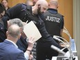 A defendant is led into the courtroom, at the Higher Regional Court at the start of a trial, in Stuttgart, Germany, Monday, April 29, 2024.