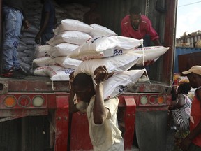 A man unloads bags of rice at a market in the Petion-Ville neighborhood of Port-au-Prince, Haiti, Wednesday, April 10, 2024.