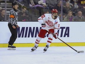 Boston University's Lane Hutson (20) looks to pass the puck during the third period of a regional final against Minnesota in the men's NCAA college hockey tournament, Saturday, March 30, 2024, in Sioux Falls, S.D.