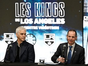 Luc Robitaille and Eric Girard sit at a table with a large banner behind them announcing the Los Angeles Kings at the Videotron Centre