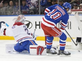 Rangers' Artemi Panarin is seen sliding the puck into an empty net behind a Canadiens goalie Cayden Primeau, who is seen hopelessly stretching his left pad in an effort to stop him.