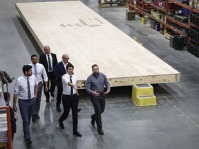 Prime Minister Justin Trudeau, second right, tours a modular home construction facility before making a housing announcement in Calgary, Alta., Friday, April 5, 2024.
