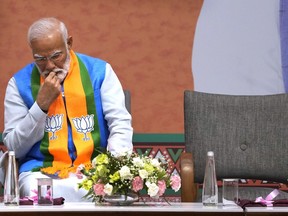 Indian Prime Minister Narendra Modi listens to Bharatiya Janata Party (BJP) president JP Nadda speak during an event organized to release their party's manifesto for the upcoming national parliamentary elections in New Delhi, India, April 14, 2024.