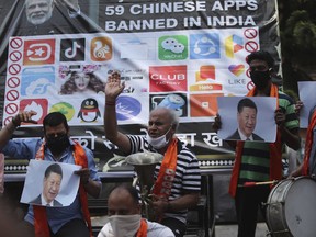 Activists of Jammu and Kashmir Dogra Front shout slogans against Chinese President Xi Jinping next to a banner showing the logos of TikTok and other Chinese apps banned in India during a protest in Jammu, India, July 1, 2020.