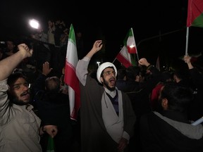 Iranian demonstrators chant slogans during their anti-Israeli gathering in front of the British Embassy in Tehran, Iran, early Sunday, April 14, 2024.